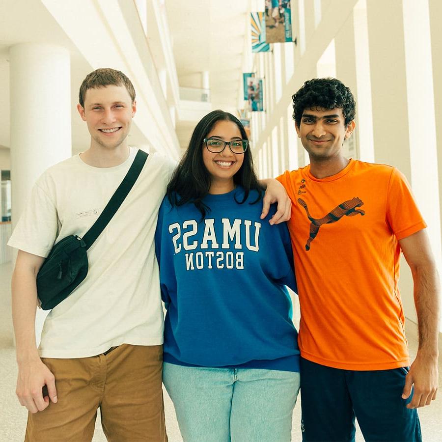 Three 马塞诸斯州大学波士顿 students, a woman and two men, smiling